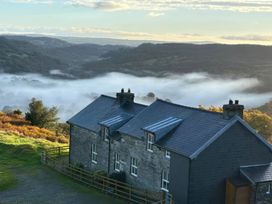 A house in a hilly landscape with fog at Ty Siabod in Capel Curig near Betws-Y-Coed