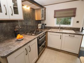 A kitchen with a gas stove oven sink and window at 117 Crosswinds in Hillway near Bembridge