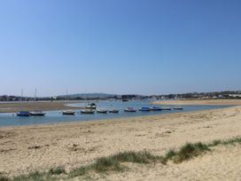 A sandy beach with small sailboats anchored in shallow water at 117 Crosswinds in Hillway near Bembridge