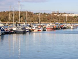 A marina with multiple boats and yachts docked along the pier with trees and buildings in the background at 117 Crosswinds Hillway near Bembridge