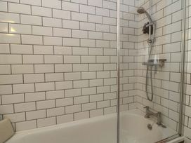 A bathroom with a shower and bathtub at Delfryn in Llandeilo