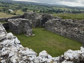 Ruins of a stone structure with grass in an outdoor setting at Delfryn Llandeilo near Llandeilo