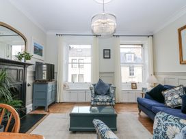 A living room with a sofa and television at 11A High Street in Jedburgh