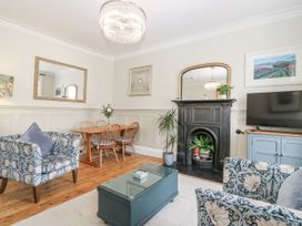 A living room with a fireplace and dining area at 11A High Street in Jedburgh