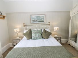 A bedroom with a bed and lamps at 11A High Street Jedburgh