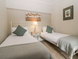 A bedroom with two single beds and a nightstand at 11A High Street, Jedburgh