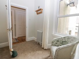 A hallway with a chair and radiator at 11A High Street, Jedburgh