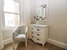 A dressing table with a mirror and flowers in a vase at 11A High Street, Jedburgh