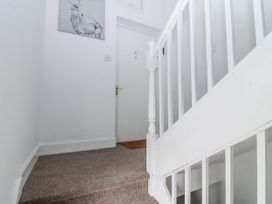A staircase and front door in a hallway at 11A High Street Jedburgh