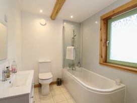 A bathroom with a sink vanity toilet bathtub shower and window at Bradan Lodge in Dalmally