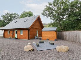 An outdoor view of a wooden house and shed at Bradan Lodge Dalmally