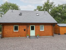 A wooden house with a gravel area at Bradan Lodge in Dalmally