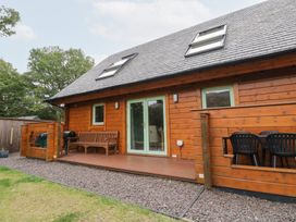 An outdoor area with a wooden house and seating at Bradan Lodge Dalmally