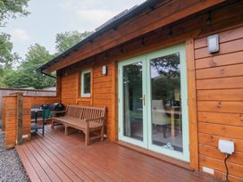 An outdoor area with wooden cabin, benches, and grill at Bradan Lodge in Dalmally