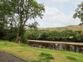 An outdoor scene with a river and trees at Bradan Lodge Dalmally