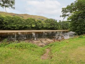 A riverside scene with trees and hills at Bradan Lodge in Dalmally
