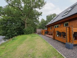 A garden with a wooden house and chairs at Bradan Lodge Dalmally