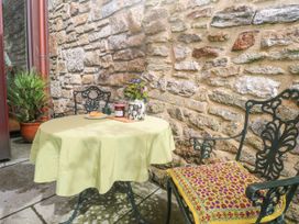 An outdoor table with a chair and a plant at The Stables in St Just