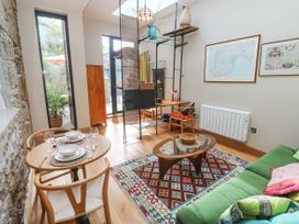 A living room with a dining table and chairs at The Stables in St Just