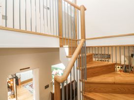 A staircase with a handrail and wall at The Stables in St Just