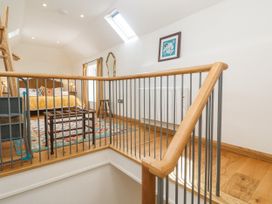 A bedroom with a bed, table, and artwork at The Stables St Just