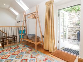 A hallway with coat rack and baskets at The Stables in St Just