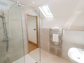 A bathroom with a shower, towel rack, and sink at The Stables in St Just