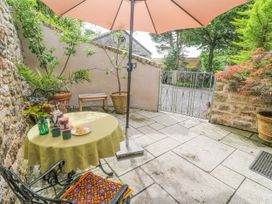 An outdoor area with a table under an umbrella at The Stables in St Just