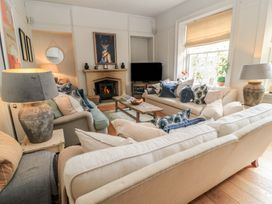 A living room with a fireplace and sofas at Cotswold House in Moreton-In-Marsh