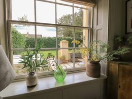 A window with plants and a view of the garden at Cotswold House in Moreton-In-Marsh