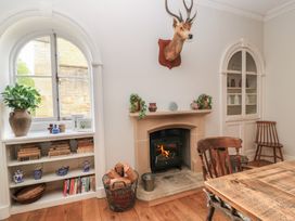 A living room with a fireplace and bookshelf at Cotswold House in Moreton-In-Marsh