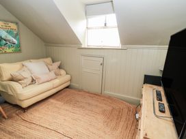 A snug with a sofa and television at Cotswold House in Moreton-In-Marsh