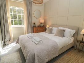 A bedroom with a bed and bedside table at Cotswold House Moreton-In-Marsh