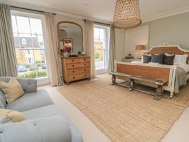 A bedroom with a bed and sofa at Cotswold House in Moreton-In-Marsh