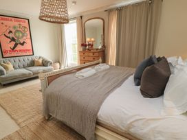 A bedroom with a bed and a sofa at Cotswold House Moreton-In-Marsh