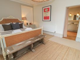 A bedroom with a bed and a doorway to an ensuite at Cotswold House in Moreton-In-Marsh