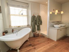 A bathroom with a bathtub and a walk-in shower at Cotswold House in Moreton-In-Marsh