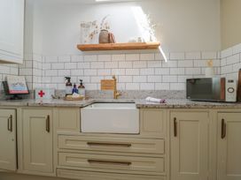 A kitchen with a sink and a microwave at Cotswold House Moreton-In-Marsh