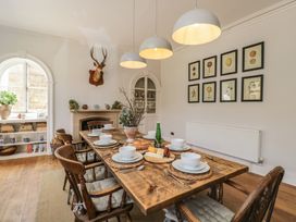 A dining room with a wooden table set for a meal at Cotswold House Moreton-In-Marsh