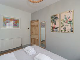A bedroom with a bed and artworks at Cotswold House in Moreton-In-Marsh