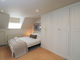 A bedroom with a bed and wardrobe at Cotswold House, Moreton-In-Marsh