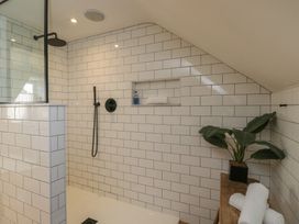 A bathroom with a shower and shelf at Cotswold House in Moreton-In-Marsh