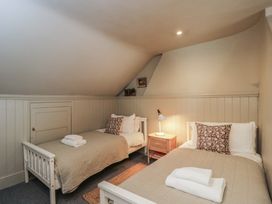A bedroom with two beds and a lamp at Cotswold House in Moreton-In-Marsh