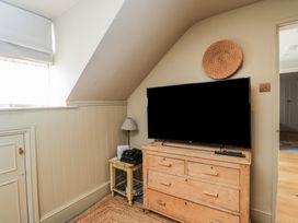 A living room with a television and drawers at Cotswold House in Moreton-In-Marsh