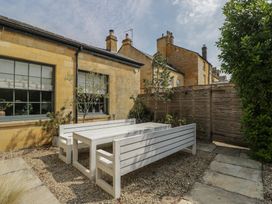A garden with a table and benches at Cotswold House in Moreton-In-Marsh