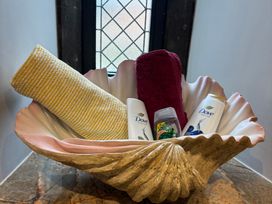 A shell bowl containing towels and Dove products at St Edmunds Church in Fraisthorpe
