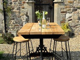 An outdoor dining area with a table and stools at St Edmunds Church in Fraisthorpe