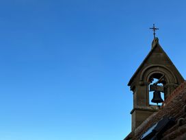 A bell tower with a cross at St Edmunds Church in Fraisthorpe
