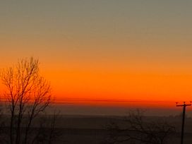 A sunset view with silhouetted trees and power lines at St Edmunds Church in Fraisthorpe