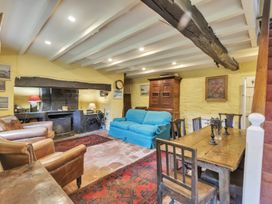 A living room with a blue sofa leather chairs wooden dining table and fireplace at Tan Y Clogwyn Dolwyddelan near Betws-Y-Coed
